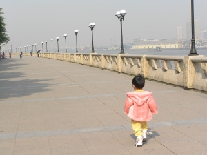 A child wanders and walks off from her mother.